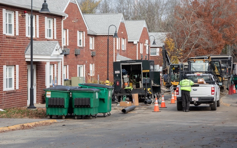 construction workers outside homes in Framingham installing geothermal pipe