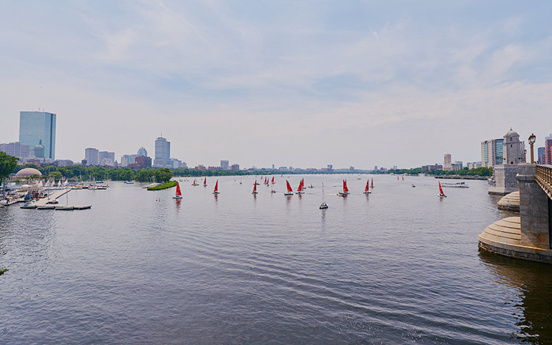 Charles River, dotted with boats, with the city skyline in the background